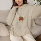 Woman sitting on a sofa in a beige hoodie with a small tteokbokki print