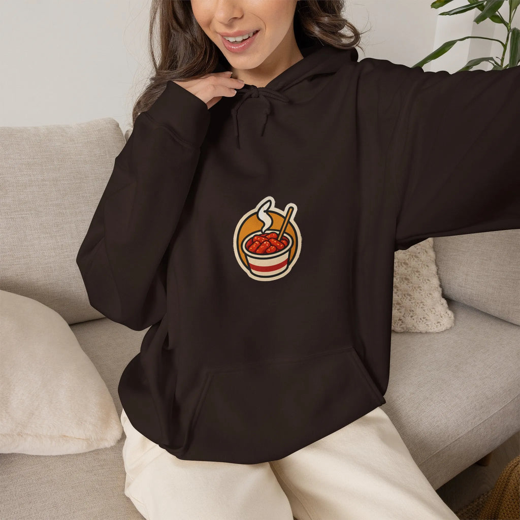 Woman relaxing on a sofa in a coffee brown hoodie with a small tteokbokki print