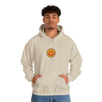 Man wearing a beige hoodie with a small smiley face print on the chest