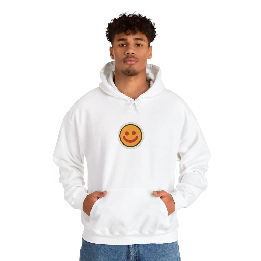 Man in an off-white hoodie with a small smiley face print on the chest