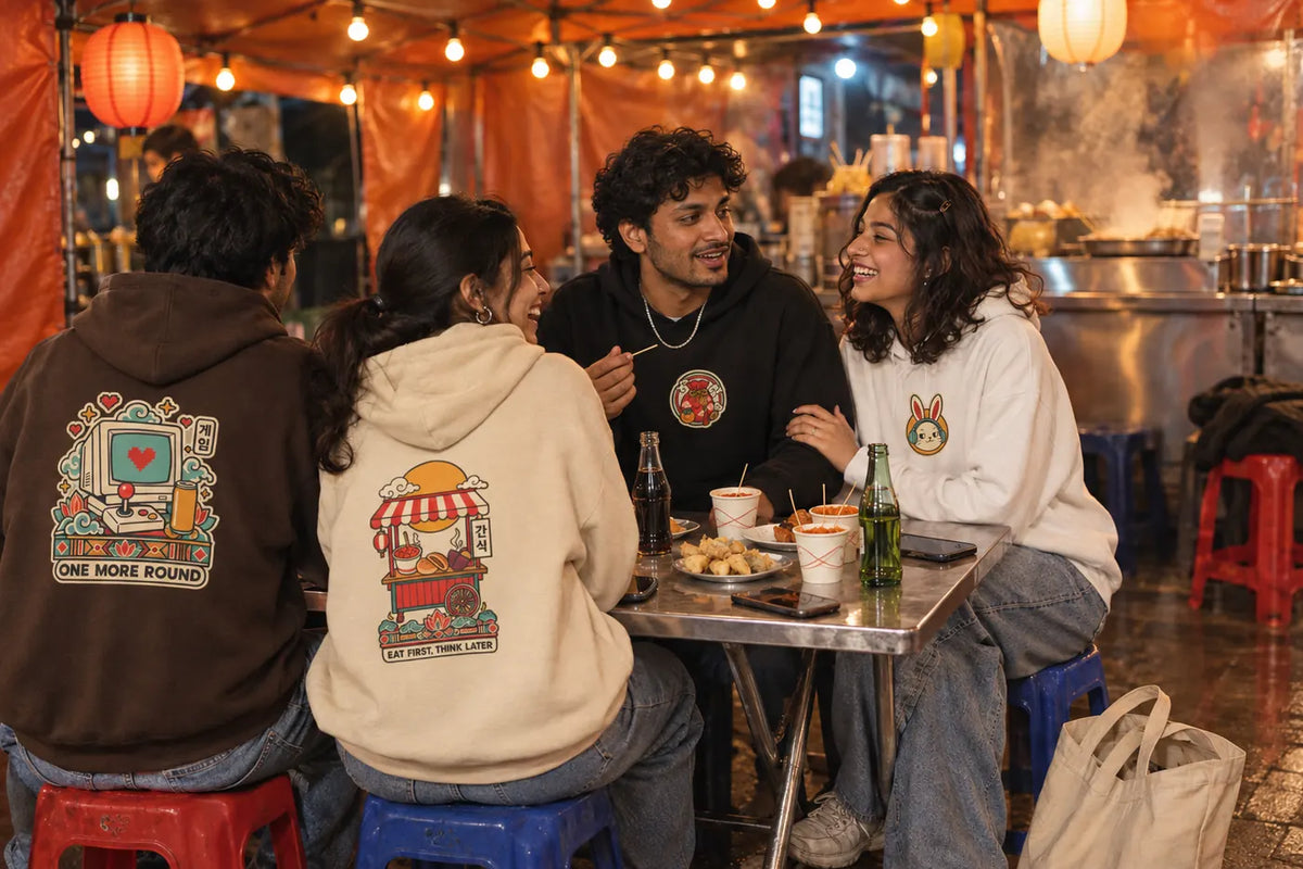 Four friends at a night street food stall wearing One More Round, Eat First Think Later, Luck Loading and Old Soul New Sneakers Korean hoodies