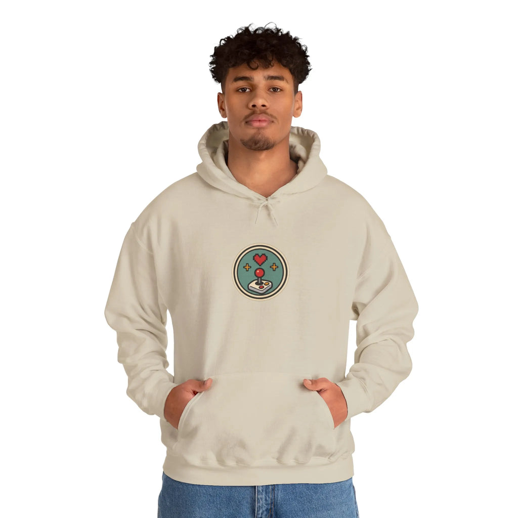 Man wearing a beige hoodie with a small round gaming badge on the chest