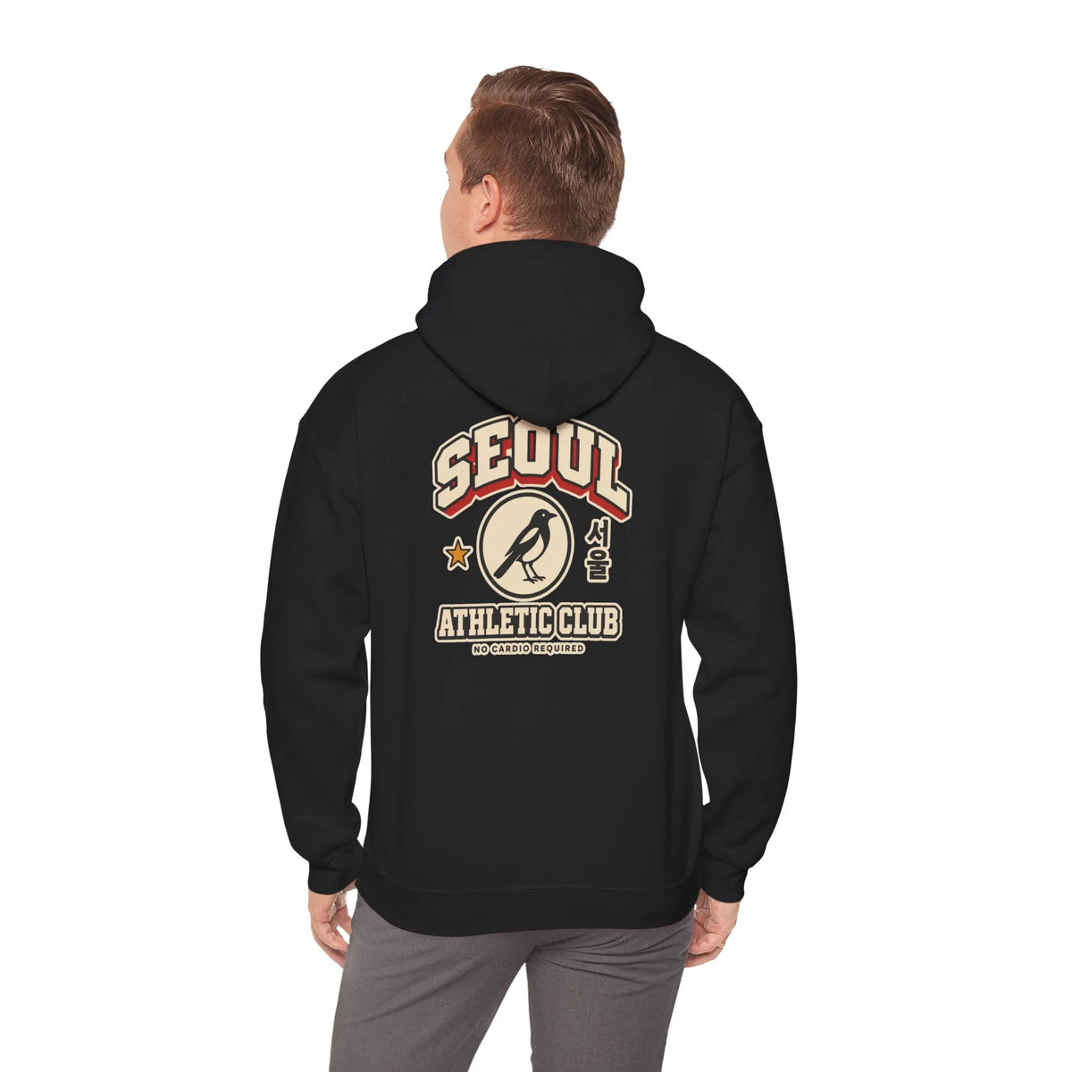 Back view of a black hoodie with a varsity-style SEOUL athletic print, worn by a man