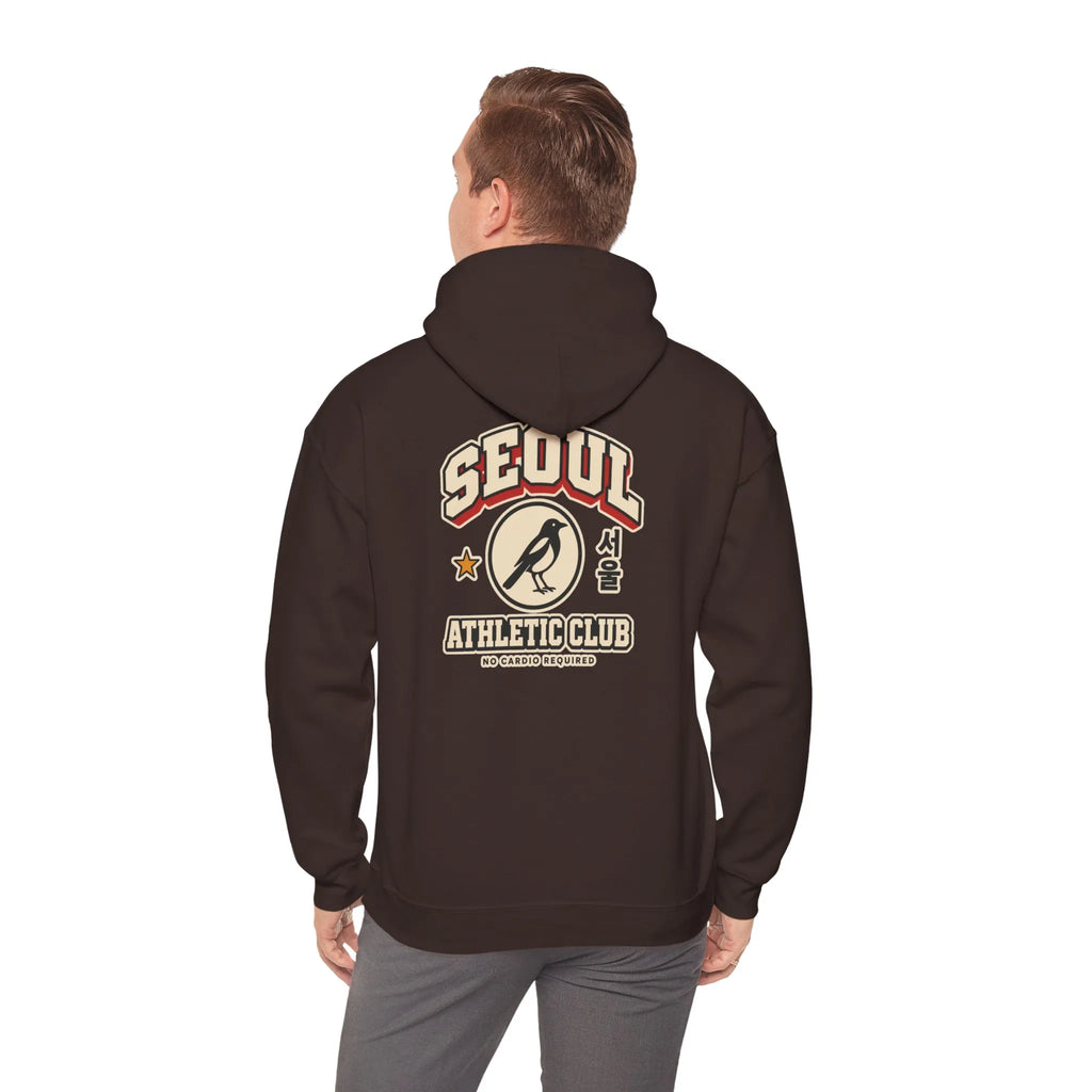 Back view of a coffee brown hoodie with a varsity-style SEOUL athletic print, worn by a man