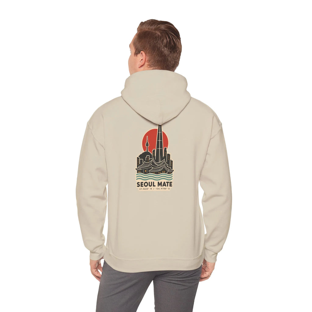 Back view of a beige hoodie with a Seoul skyline and coordinates print, worn by a man