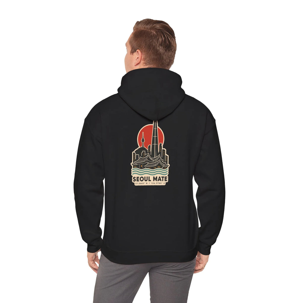 Back view of a black hoodie with a Seoul skyline and coordinates print, worn by a man