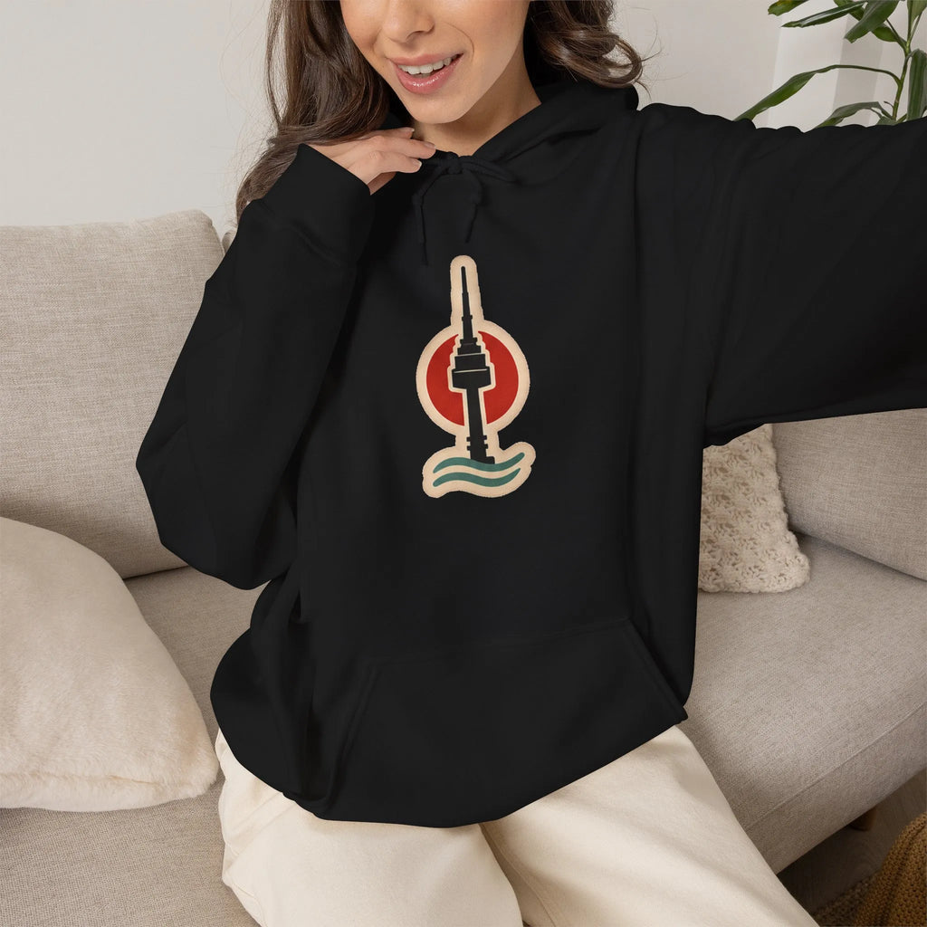 Woman sitting on a sofa in a black hoodie with a small Seoul print