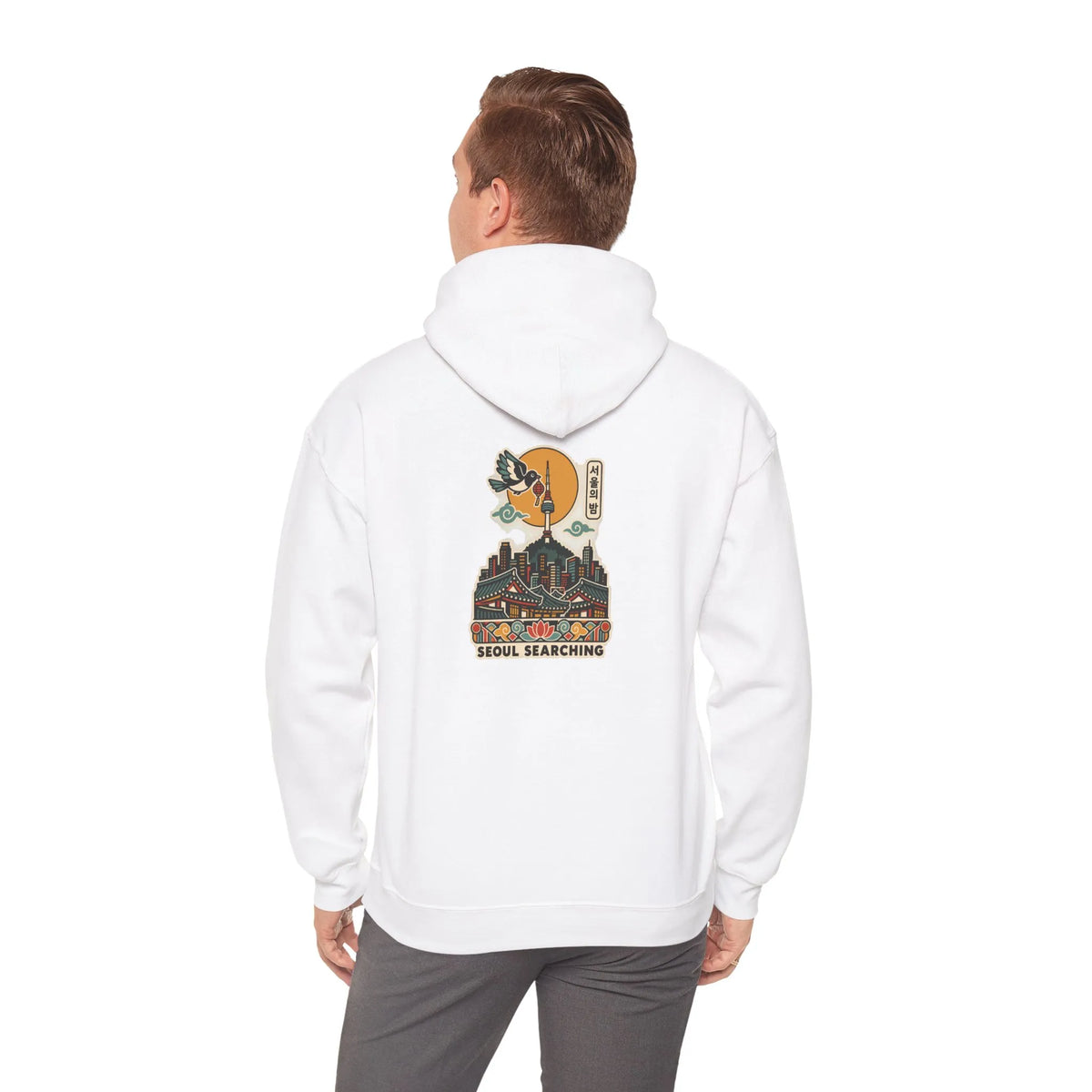Back view of an off-white hoodie with a Seoul night skyline print, worn by a man