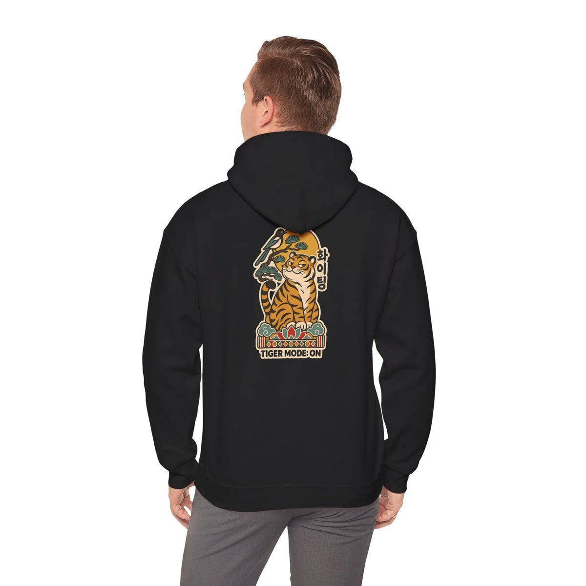 Man wearing a black oversized hoodie with a tiger print on the back