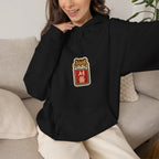 Woman sitting on a sofa in a black hoodie with a small front print