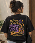 Woman wearing a black oversized Wear Pardesi t-shirt with a "No View Is Worth Staying Stuck" back print and a tower wrapped in golden hair